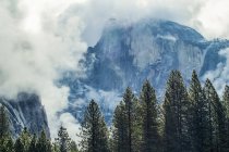 Half Dome surrounded by clouds, Yosemite National Park; California, United States of America — Stock Photo