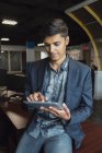 Jeune homme d'affaires millénaire tablette dans le lieu de travail moderne — Photo de stock