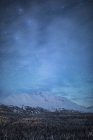 La faible lueur d'Aurora Borealis dans le ciel nocturne illumine le nuage clairsemé au-dessus de Moose Pass, péninsule de Kenai, centre-sud de l'Alaska ; Moose Pass, Alaska, États-Unis d'Amérique — Photo de stock