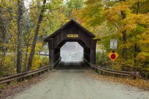 Un puente cubierto en una carretera de campo en otoño, Green Mountains; Stowe, Vermont, Estados Unidos de América - foto de stock