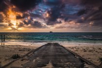 Eine Holzpromenade am Strand, die bei Sonnenuntergang zum türkisfarbenen Wasser der Hamelner Bucht führt; Westaustralien, Australien — Stockfoto