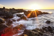 Dramatischer Sonnenuntergang über dem Ozean mit Wasserfällen entlang der zerklüfteten Küste; wailea, maui, hawaii, vereinigte staaten von amerika — Stockfoto