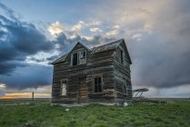 Заброшенный дом в прериях с грозовыми облаками над головой на закате; Вал-Мари, Саскачеван, Канада — стоковое фото