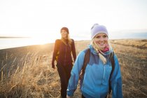 Two young women hiking along the coast at sunrise; Anchorage, Аляска, США — стоковое фото