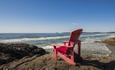Ein roter Muskoka-Stuhl am Ufer entlang der Küste, Pazifik-Rand-Nationalpark, Vancouver-Insel; britische Kolumbia, Kanada — Stockfoto
