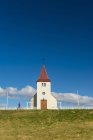 Ragazza passeggiando davanti alla chiesetta; Langaholt, Islanda — Foto stock