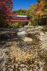 Saco River and covered bridge in autumn, White Mountains National Forest; Conway, New Hampshire, United States of America — Stock Photo