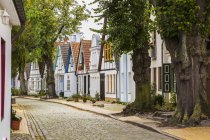 Strada residenziale con pavimentazioni rettangolari e facciate colorate con tetti in terracotta, località balneare di Warnemunde nel distretto di Rostock; Rostock, Germania — Foto stock