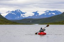 Mann paddelt mit Packfloß über Grenzstein Gap Lake, Alaska, USA — Stockfoto
