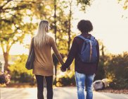 Boyfriend and girlfriend holding hands on the university campus at sunset — Stock Photo
