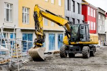 Large wheel loader in front of colorful buildings — Stock Photo