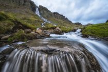 Sfocatura del moto dell'acqua che scorre in una cascata vicino a Djupavik; fiordi occidentali, Islanda — Foto stock