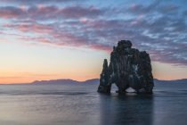 La formación rocosa conocida como Hvitserkur, al atardecer, al norte de Islandia; Islandia - foto de stock