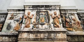 Выветриваемая стена, украшенная традиционными индийскими и индуистскими фигурами; Ришикеш, Уттаракханд, Индия — стоковое фото