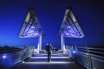 Homem caminhando na ponte Terwillegar Park ao anoitecer, Edmonton, Alberta, Canadá — Fotografia de Stock