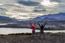 Dos mujeres viajeras celebran en el hermoso mirador de la naturaleza en Islandia - foto de stock