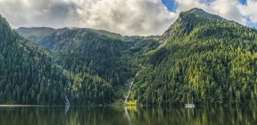 Scenic view of the Great Bear Rainforest area with a sailboat on the water; Hartley Bay, British Columbia, Canada — Stock Photo