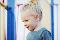 Primo piano di giovane ragazza con i capelli biondi che gioca in un parco giochi — Foto stock