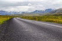 Die offene Autobahn führt in die Berglandschaft im westlichen Island, Island — Stockfoto