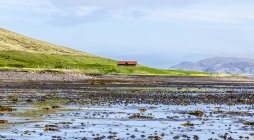 Одноэтажный дом на окраине горы Киркьюфелл и Атлантического океана на полуострове Снайфелльснес, Западная Исландия, Грюндарфьор, Исландия — стоковое фото