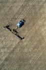Luftaufnahme eines Traktors, der Rollen zieht, um ein Feld zu glätten — Stockfoto