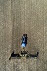 Vista aérea de un tractor tirando de rodillos para aplanar un campo - foto de stock