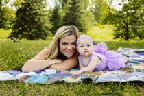 Мати і дочка, що лежить на пікнік ковдрі — стокове фото