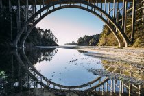 Frederick W. Panhorst Bridge reflected in water to show a mirror image, Russian Gulch State Park, California, USA — Stock Photo