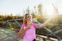 Caucasian mid adult sporty woman taking selfie outdoors — Stock Photo