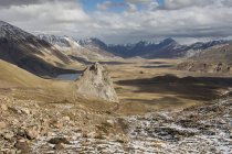 Amplio valle estéril se ve desde una cresta con las montañas circundantes en polvo con una capa de nieve fresca, Malargue, Mendoza, Argentina - foto de stock