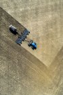 Вид з повітря на трактор, що тягне за собою повітряну сівалку, посіявши поле — стокове фото