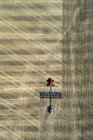 Вид з повітря на трактор, що тягне за собою повітряну сівалку, посіявши поле — стокове фото