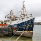 Barco amarrado en el puerto a lo largo de la costa oeste de Irlanda en la desembocadura de la bahía de Galway, Inishmore, Islas Aran; Kilronan, Condado de Galway, Irlanda - foto de stock