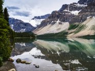 Des montagnes Rocheuses et des glaciers canadiens accidentés se reflètent dans un lac tranquille, le parc national Banff ; le district d'amélioration no. 9, Alberta, Canada — Photo de stock