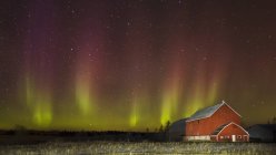 Fienile rosso di notte con aurora boreale; Thunder Bay, Ontario, Canada — Foto stock
