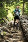 Wanderin auf einem steinigen Pfad im Wald; Britische Kolumbia, Kanada — Stockfoto