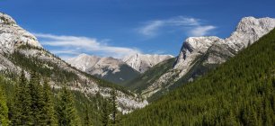 Panoramic view of valley and mountain range with blue sky and clouds, South of Canmore, Alberta, Canada — Stock Photo