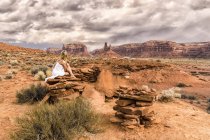 Une femme est assise sur un rocher dans la Vallée des Dieux ; Utah, États-Unis d'Amérique — Photo de stock