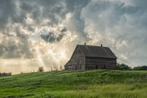 Abandoned barn with storm clouds converging overhead; Nebraska, United States of America — Stock Photo