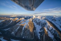 Imagen aérea de las montañas de San Elías en el Parque Nacional y Reserva de Kluane con una vista de la parte inferior de un ala de avión; Haines Junction, Yukón, Canadá - foto de stock