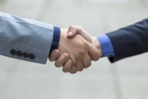 Two young men shaking hands; Bothell, Washington, United States of America — Stock Photo