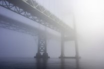 The Tacoma Narrows Bridges in the fog from the water surface. Tacoma, Washington, United States of America — Stock Photo