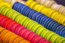 Primer plano de macarrones coloridos todo en una fila en escaparate tienda - foto de stock