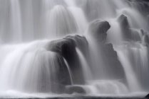 Close-up de água corrente no fundo de uma cachoeira; Islândia — Fotografia de Stock