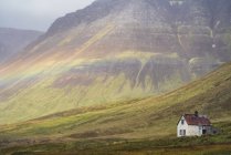 Слабая радуга над заброшенной исландской усадьбой; Западные фьорды, Исландия — стоковое фото