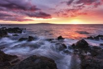Agua blanda sobre rocas de lava con una puesta de sol roja, Makena, Maui, Hawaii, Estados Unidos de América - foto de stock