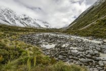 Каменистая горная река вдоль трака долины Хукер, Национальный парк Маунт-Кук; Южный остров, Новая Зеландия — стоковое фото