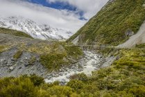 Montanhas nevadas e ponte suspensa ao longo da Hooker Valley Track, Mount Cook National Park; South Island, Nova Zelândia — Fotografia de Stock