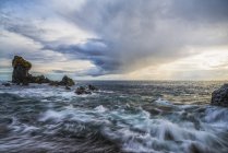 Wellen, die bei Sonnenuntergang gegen die Küste des Strandes von Djupalonssandur krachen, Schlangenhalbinsel, Island — Stockfoto