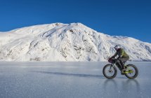 Mann fährt Fatbike über zugefrorenen Portage-See mitten im Winter in Süd-Zentralalaska, Vereinigte Staaten von Amerika — Stockfoto